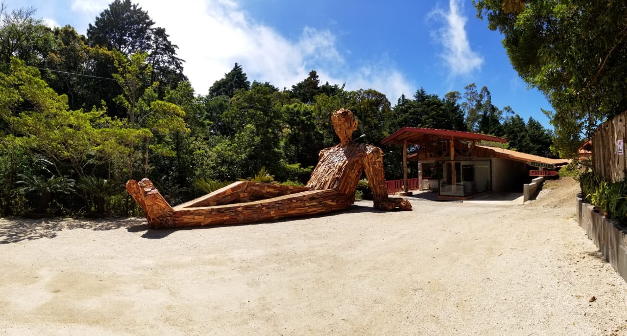 Eine Riesenskulptur aus Holz und recyceltem Metall "chillt" in der Sonne Costa Ricas vor dem Selina Hotel in Monteverde.